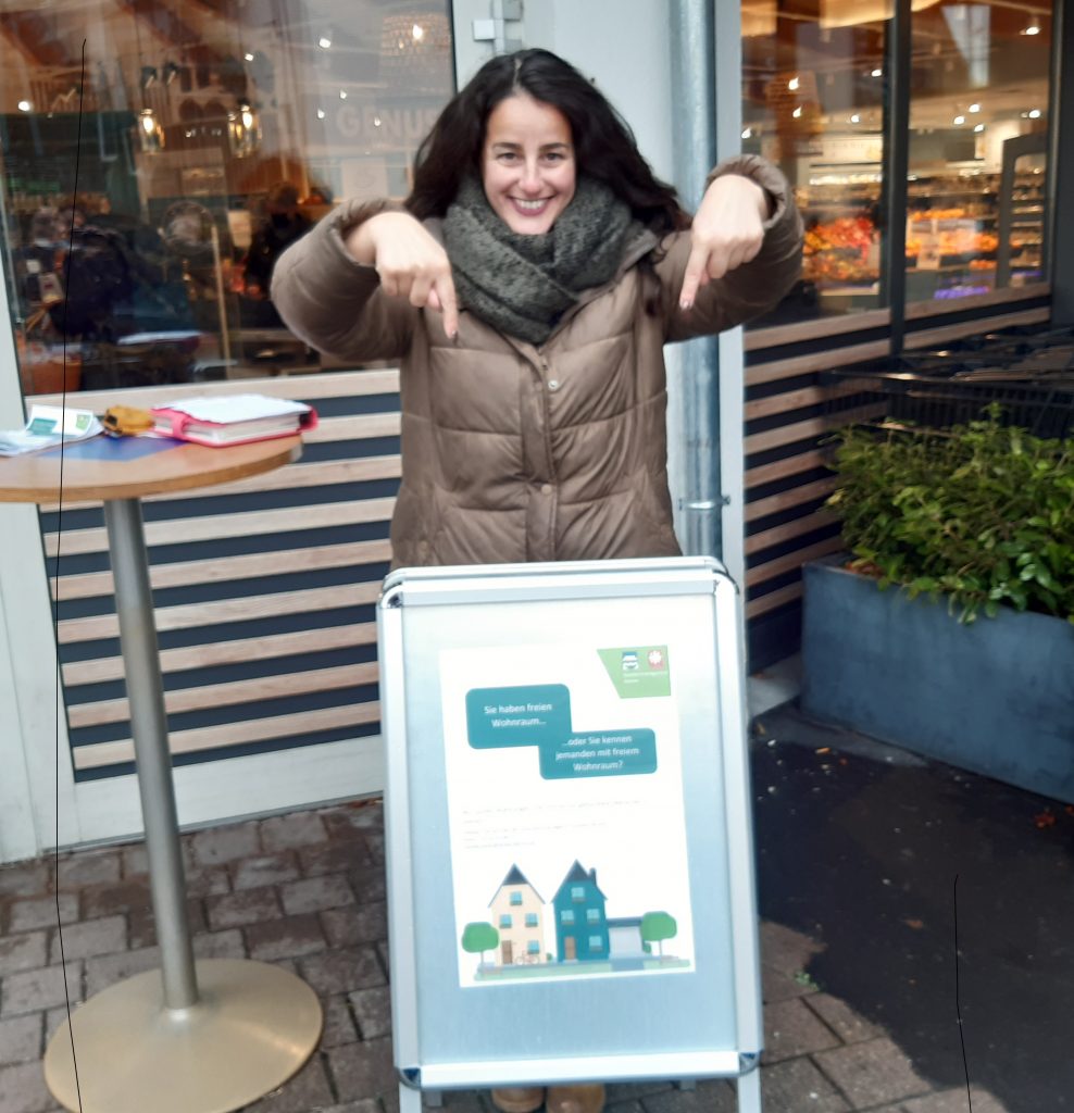 Quartiersmanagerin am Stand mit Kundenstopper